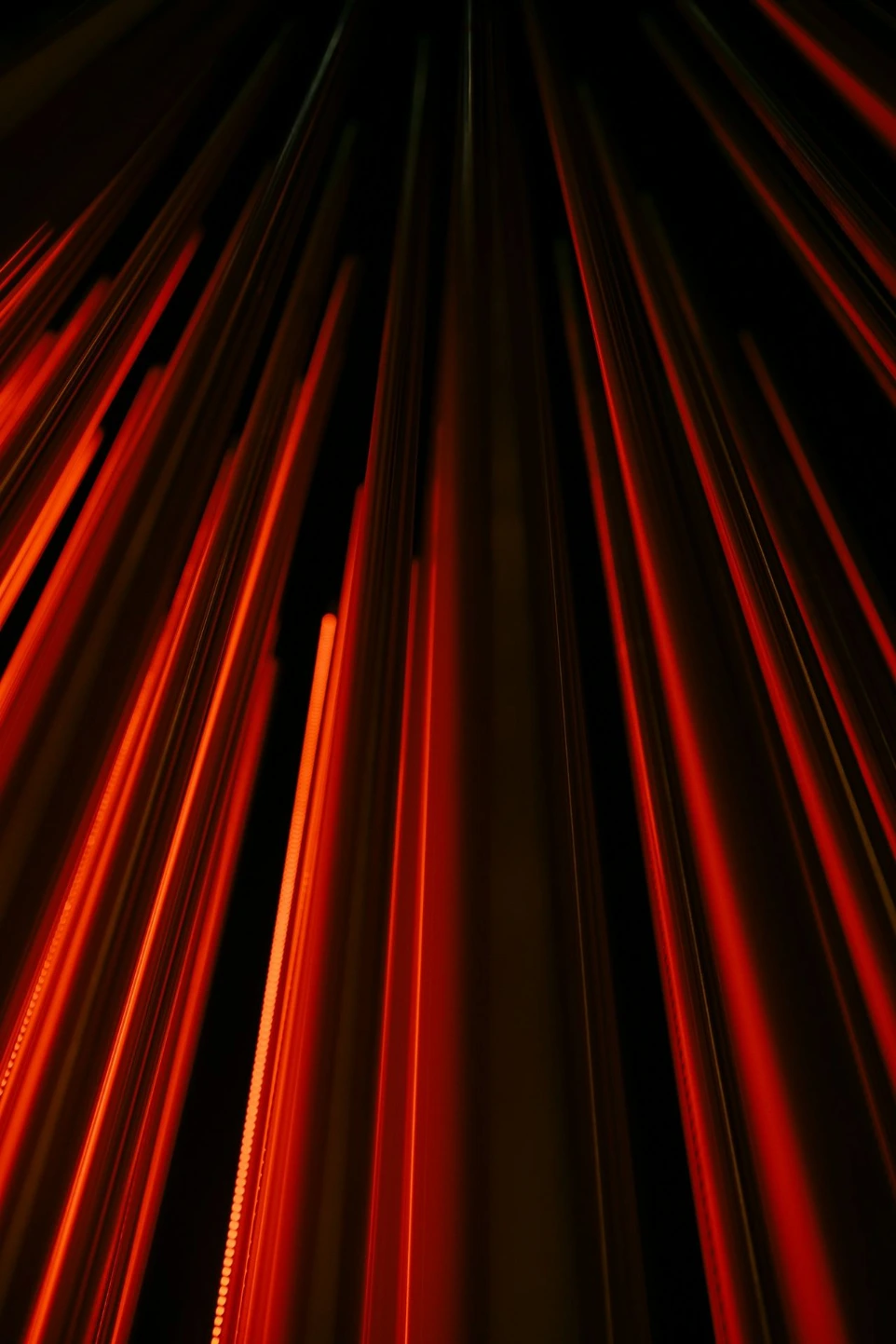 Vertical red light streaks converging toward the top against a black background